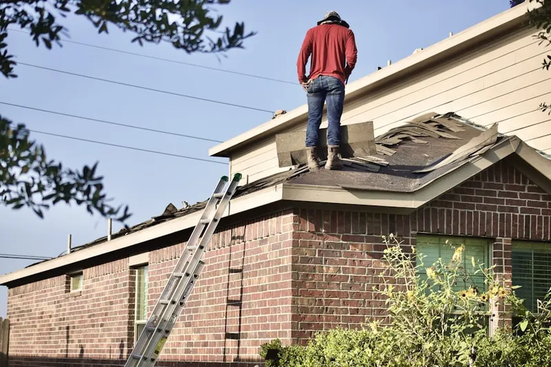 Professional roofer working on a residential roof in Palisades Corner